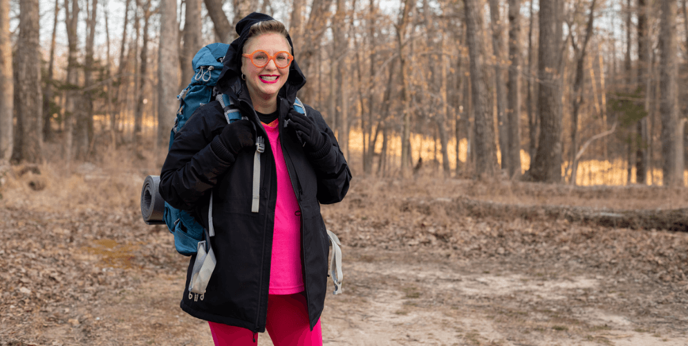 smiling woman wearing camping gear